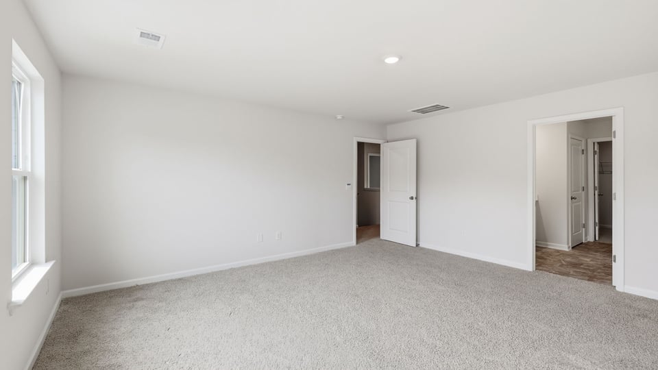 Bedroom with carpet and window.