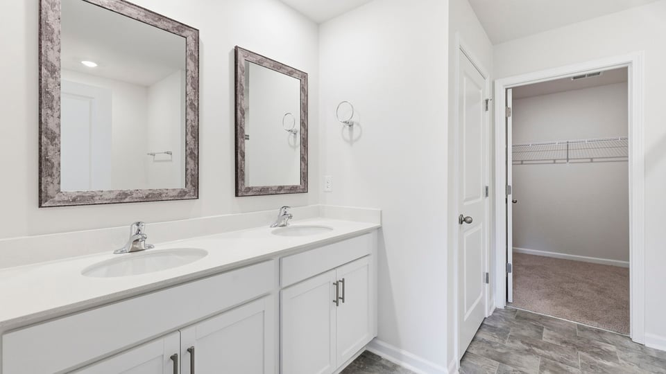 Bathroom with double vanity sink and walk in closet.
