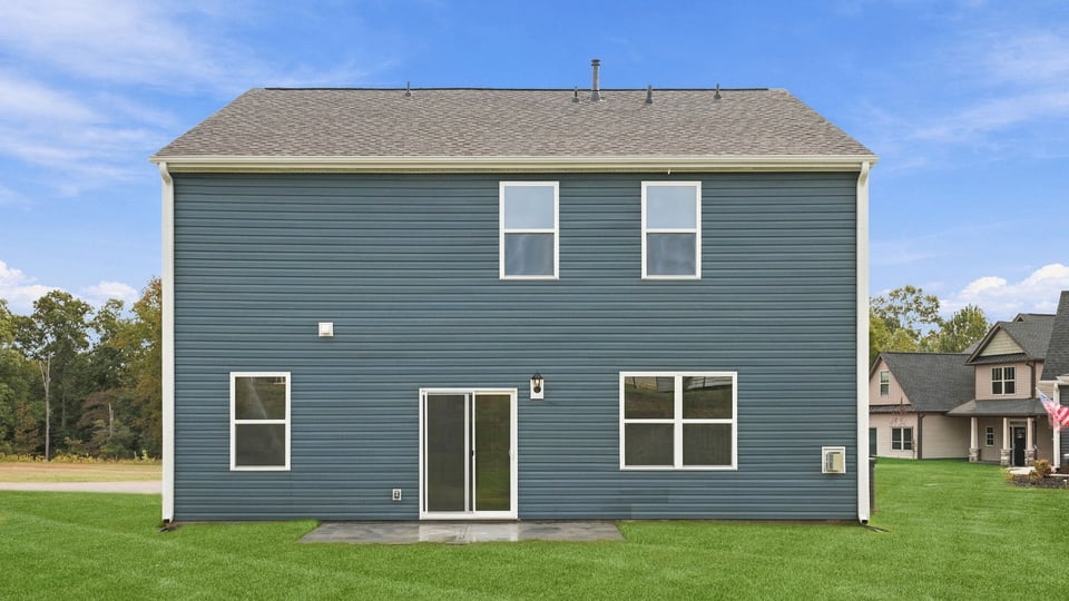 Back exterior of home with large backyard.