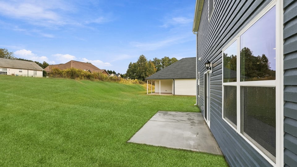 Back exterior of home with small patio.
