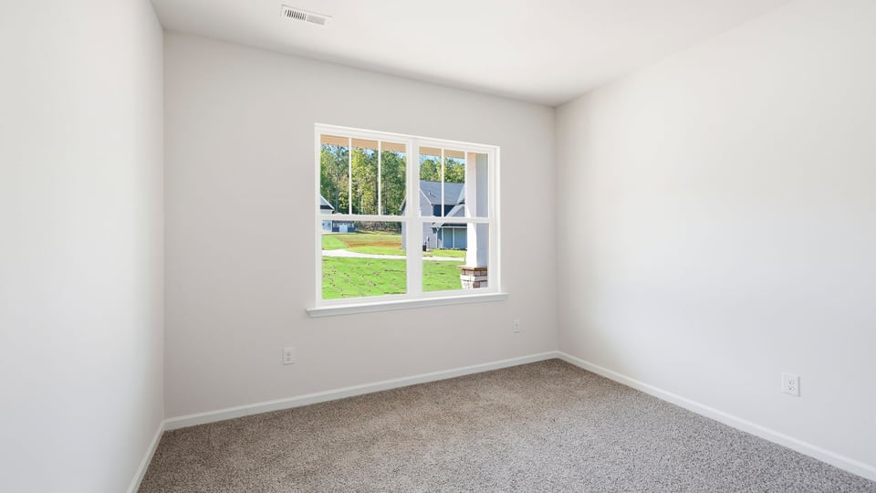 Bedroom with carpet and window.