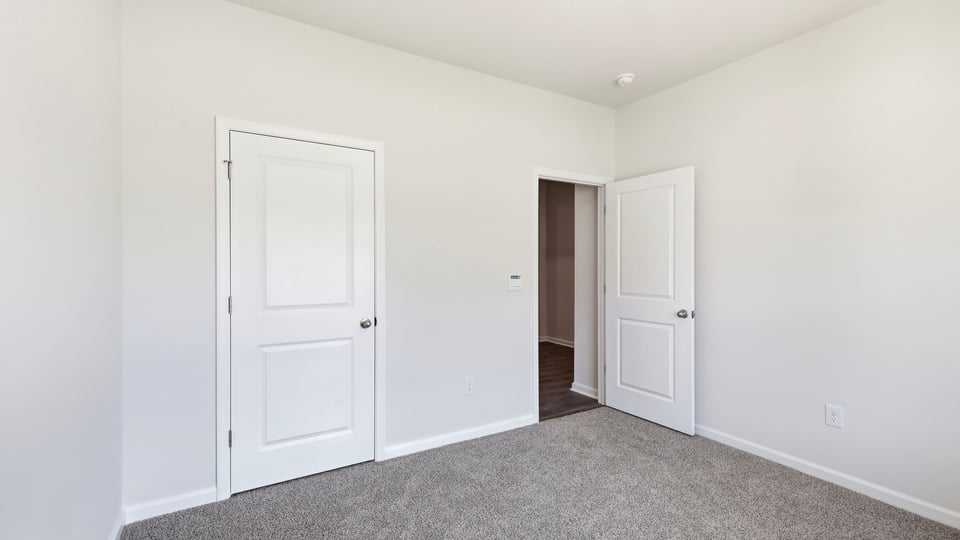 Bedroom with carpet and window.