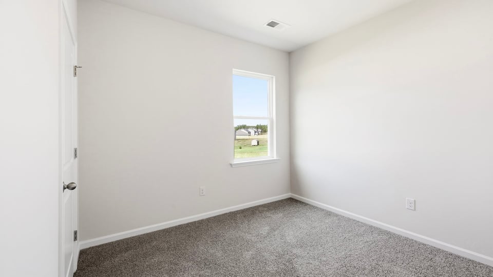Bedroom with carpet and window.