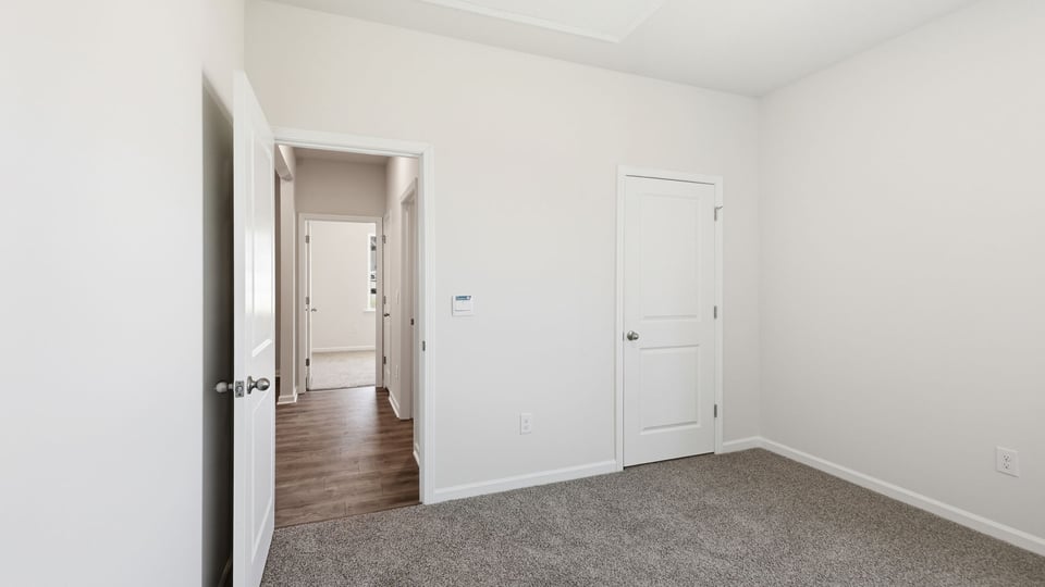 Bedroom with carpet and window.