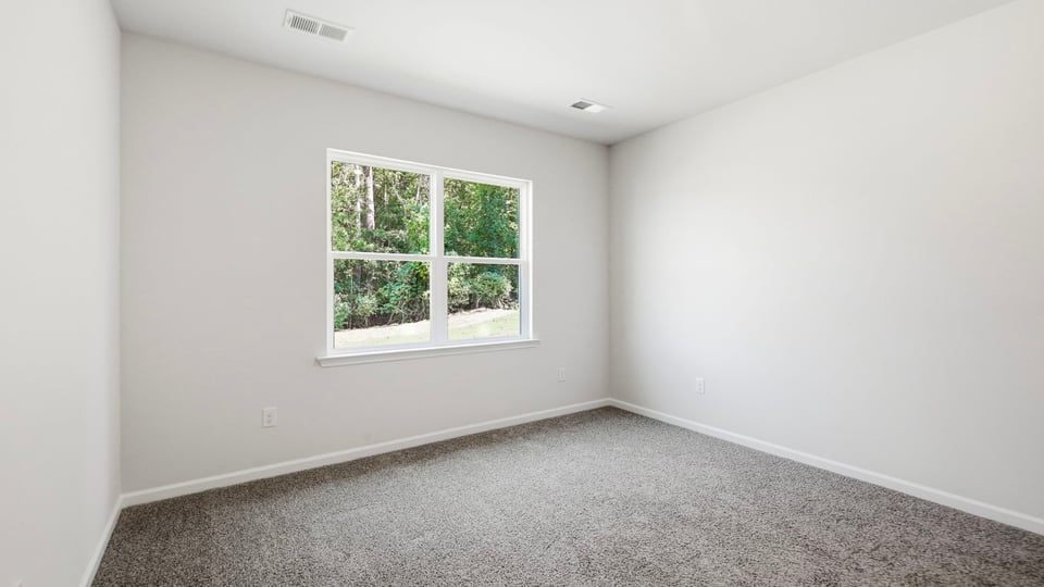 Bedroom with carpet and window.