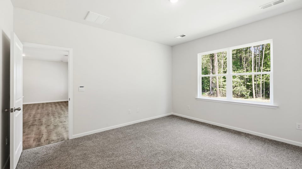 Bedroom with carpet and window.