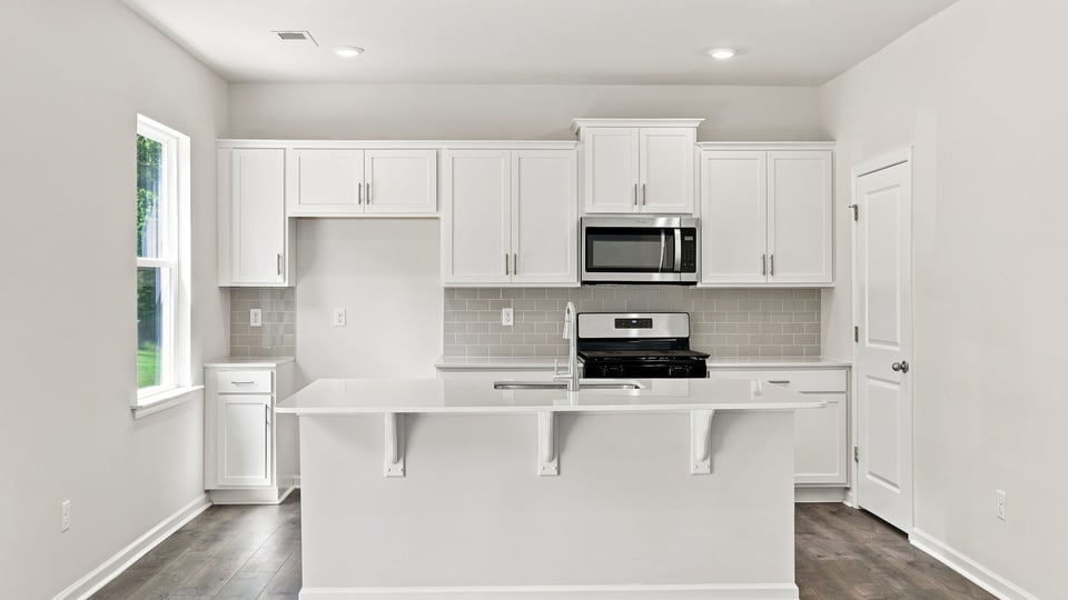 Kitchen and island with quartz countertops.