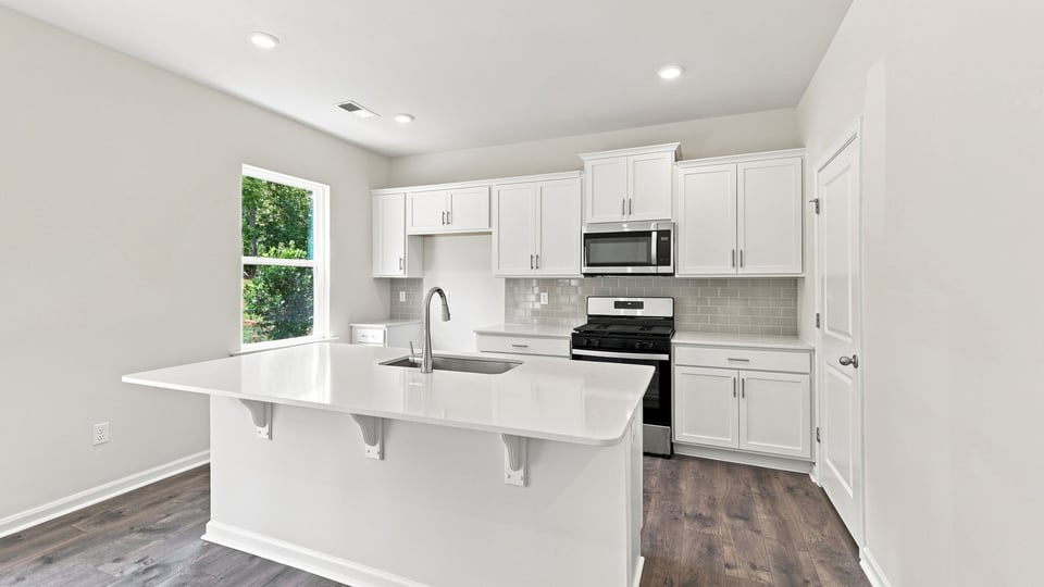 Kitchen and island with quartz countertops.
