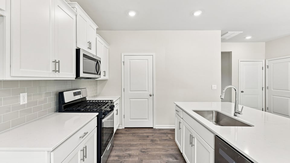 Kitchen and island with quartz countertops.
