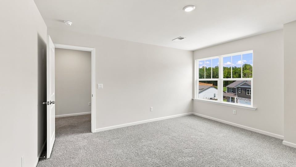 Bedroom with carpet and window.