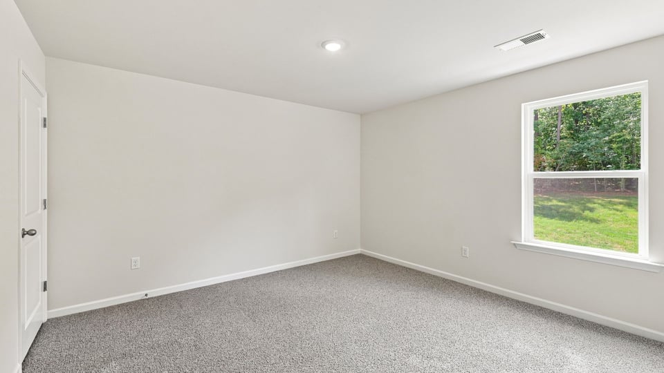 Bedroom with carpet and window.