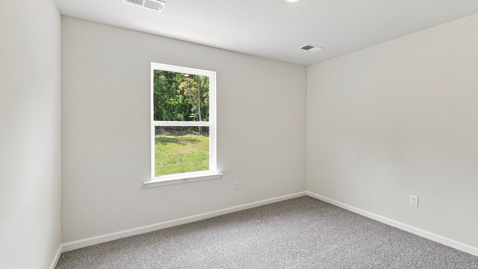 Bedroom with carpet and window.