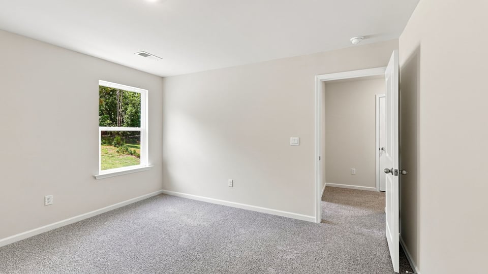 Bedroom with carpet and window.