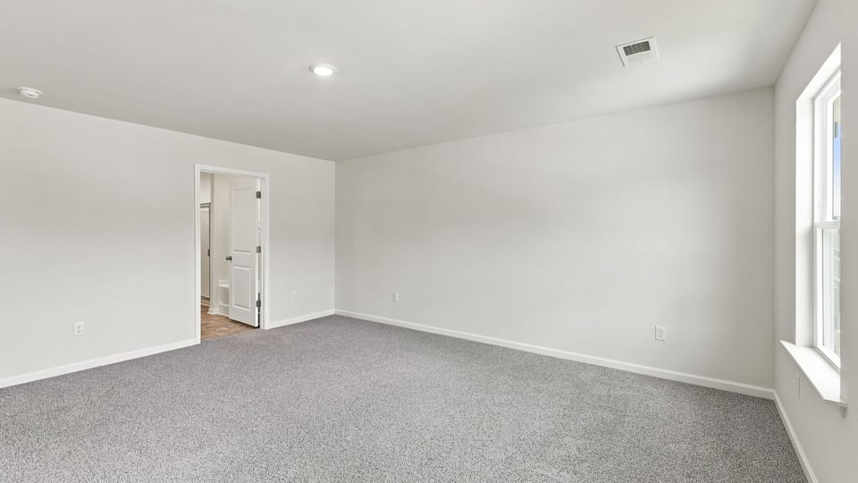 Bedroom with carpet and window.