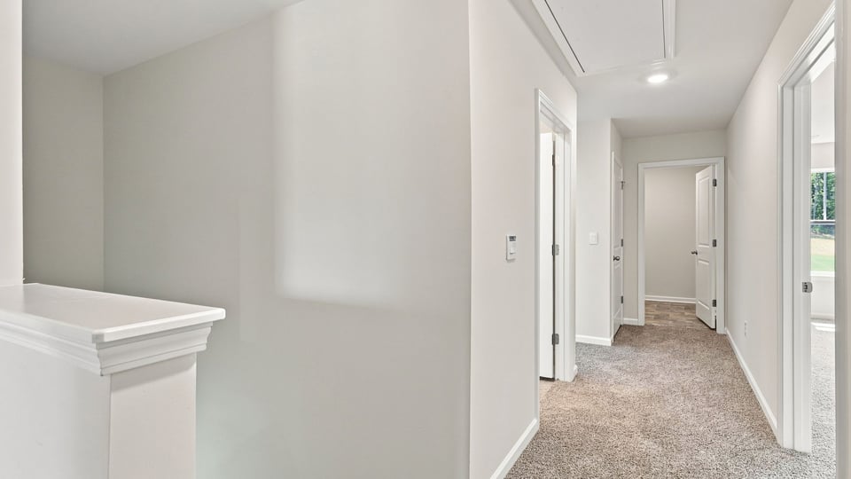 Hallway to bedrooms with carpet.