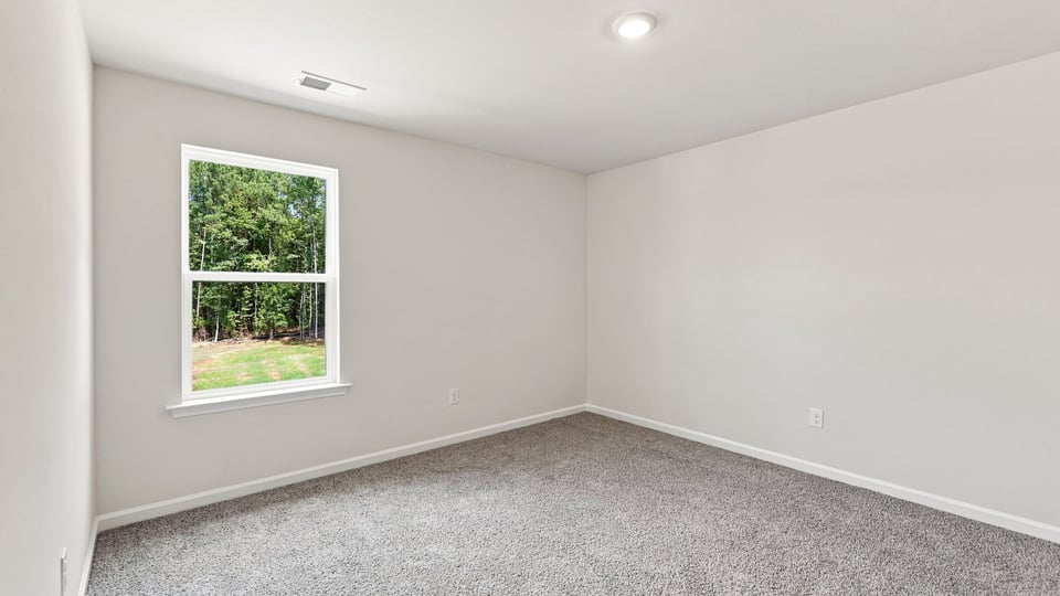 Bedroom with carpet and windows.