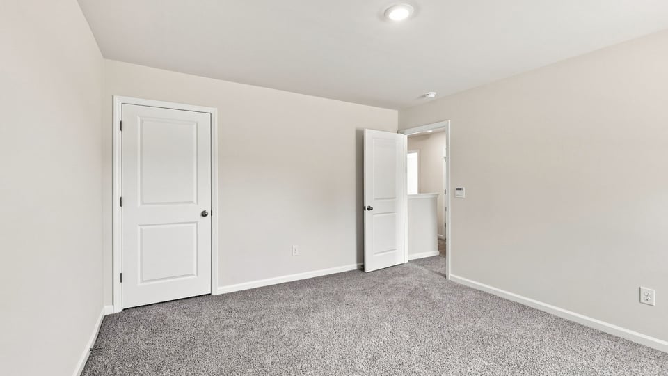 Bedroom with carpet and windows.