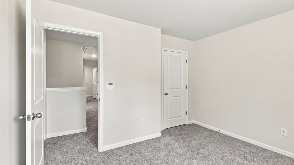 Bedroom with carpet and windows.