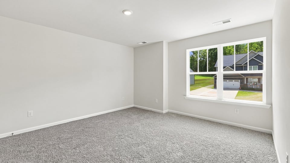 Bedroom with carpet and windows.