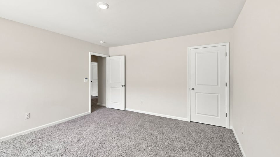 Bedroom with carpet and windows.