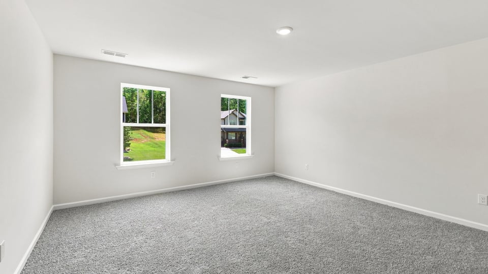 Bedroom with carpet and windows.