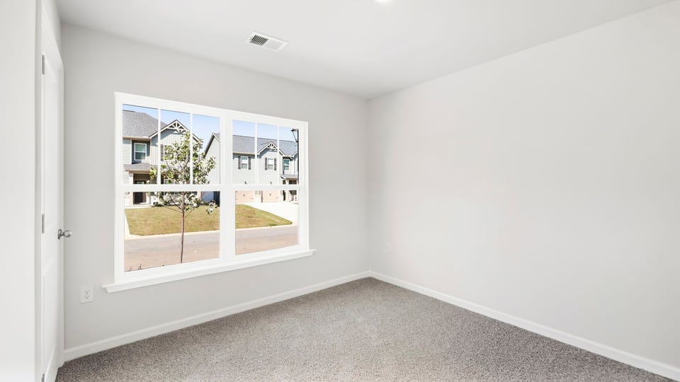 Bedroom with carpet and window.