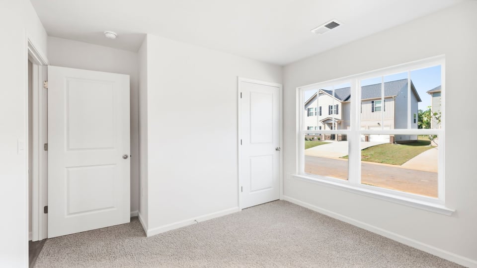 Bedroom with carpet and window.