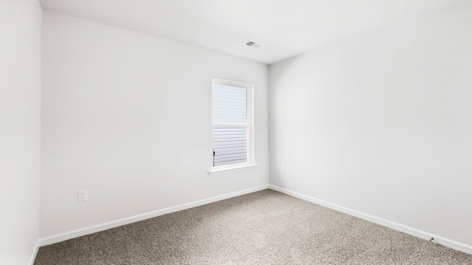 Bedroom with carpet and window.