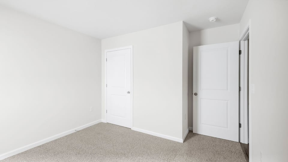 Bedroom with carpet and window.