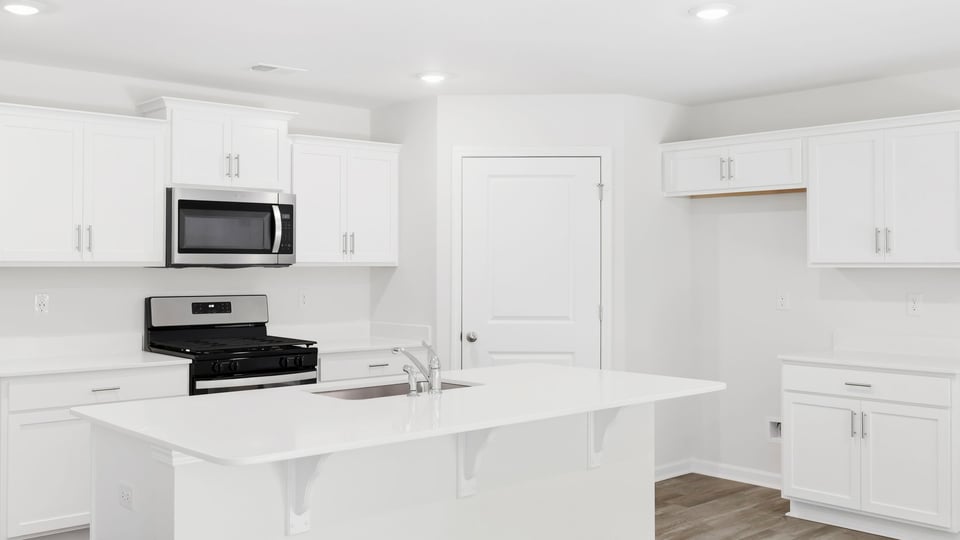 Kitchen and island with quartz countertops.