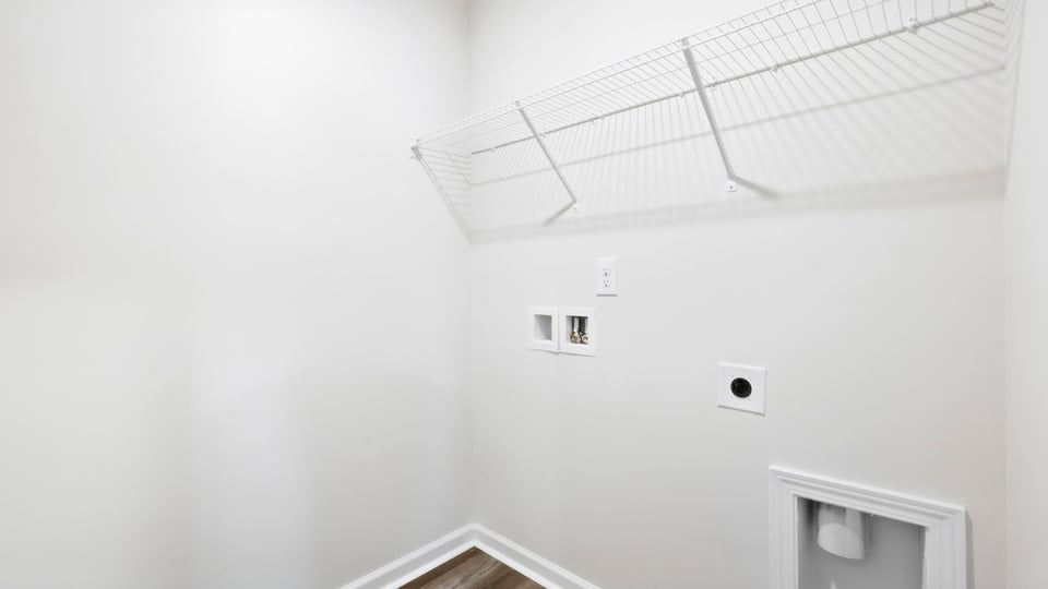 Laundry room with hanging storage racks.