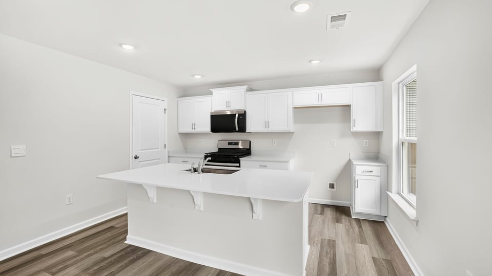 Kitchen and island with quartz countertops.