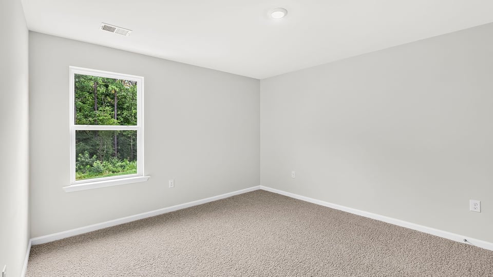 Bedroom with carpet and window.