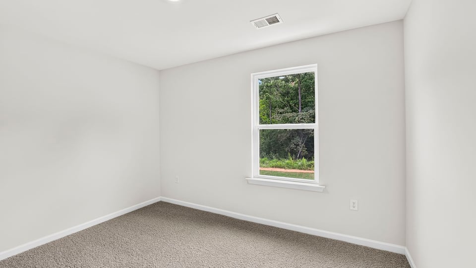 Bedroom with carpet and window.
