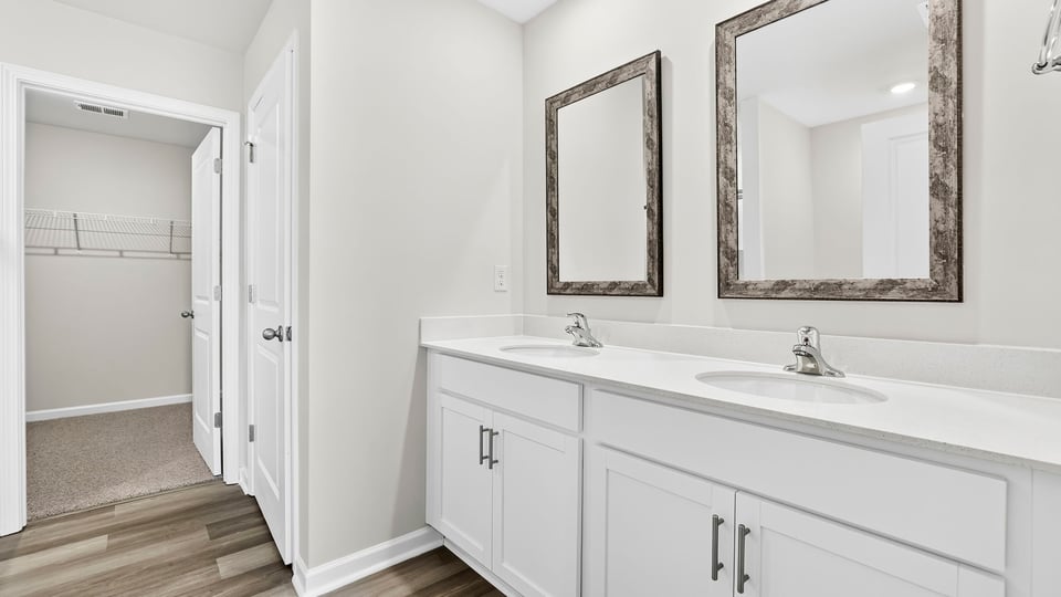 Bathroom with double vanity sink and walk in closet.
