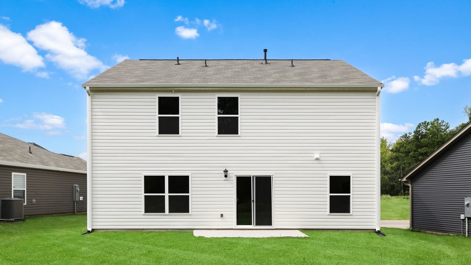 Back exterior of home with large backyard.
