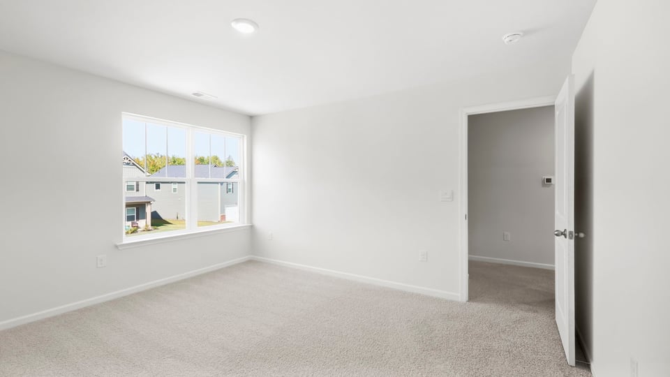 Bedroom with carpet and window.
