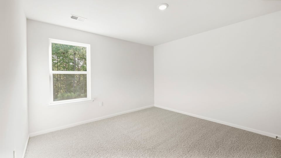 Bedroom with carpet and window.