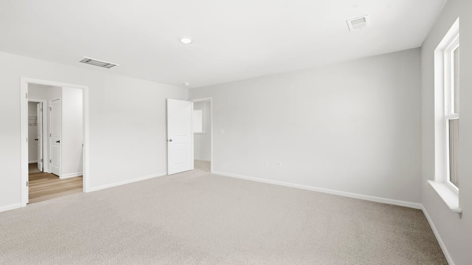 Bedroom with carpet and window.