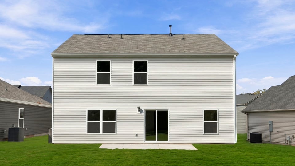 Back exterior of home with large backyard.