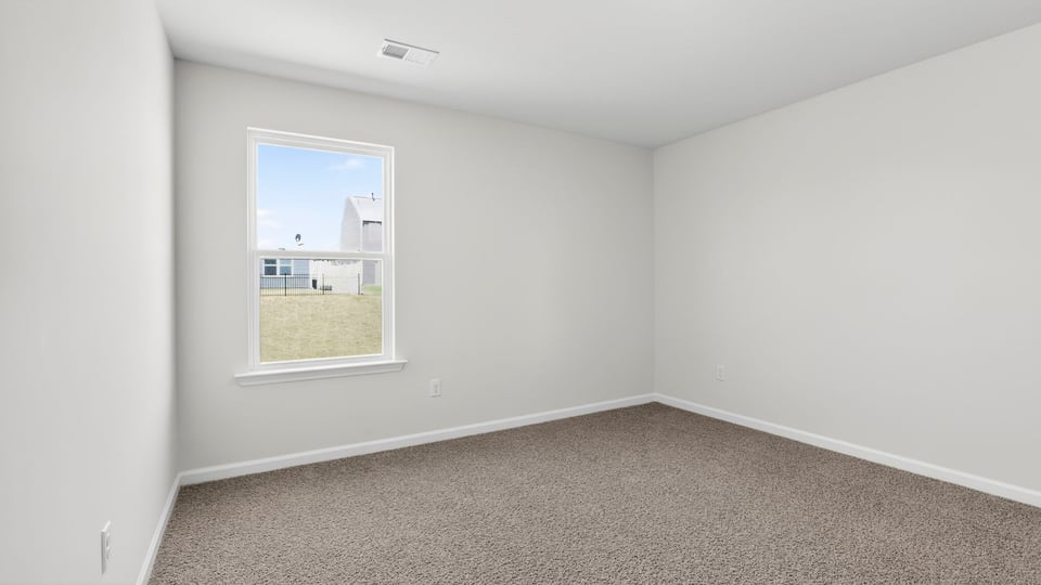 Bedroom with carpet and windows.