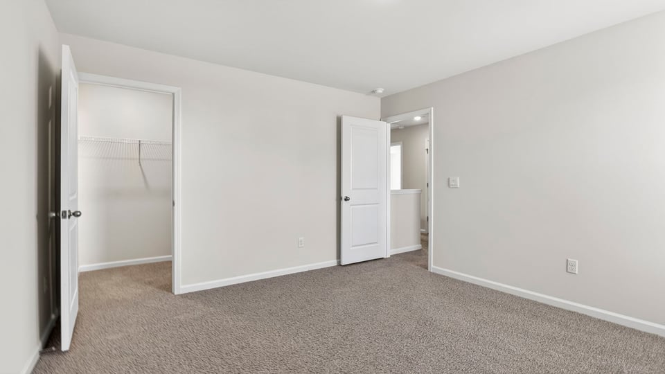 Bedroom with carpet and windows.