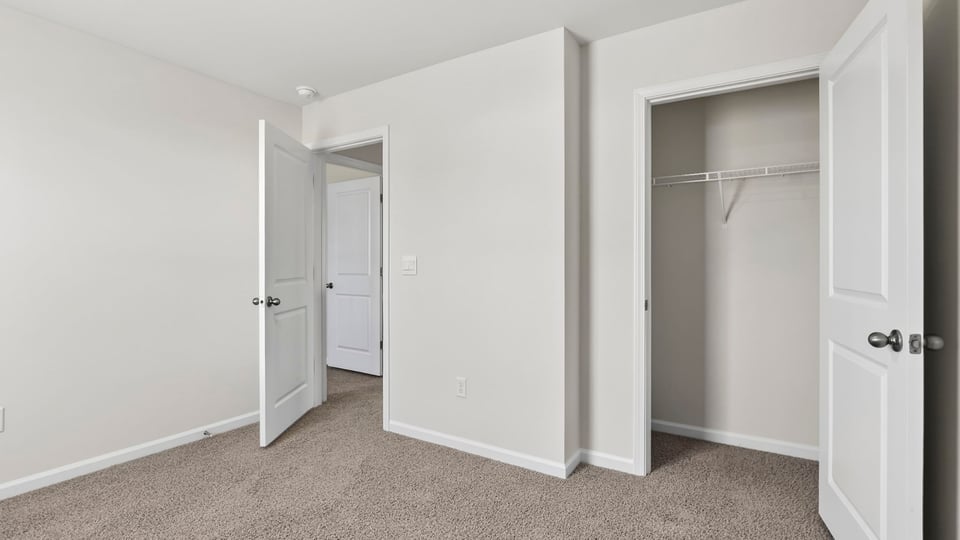 Bedroom with carpet and windows.