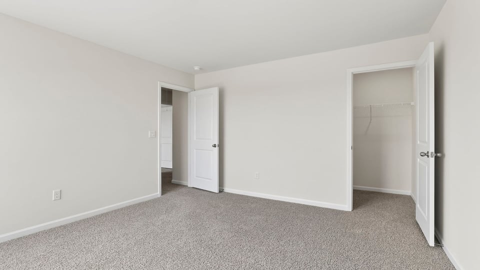 Bedroom with carpet and windows.