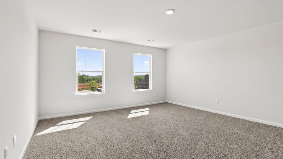 Bedroom with carpet and windows.