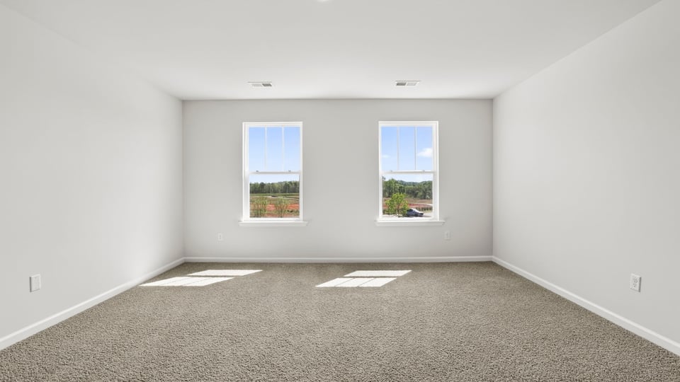 Bedroom with carpet and windows.