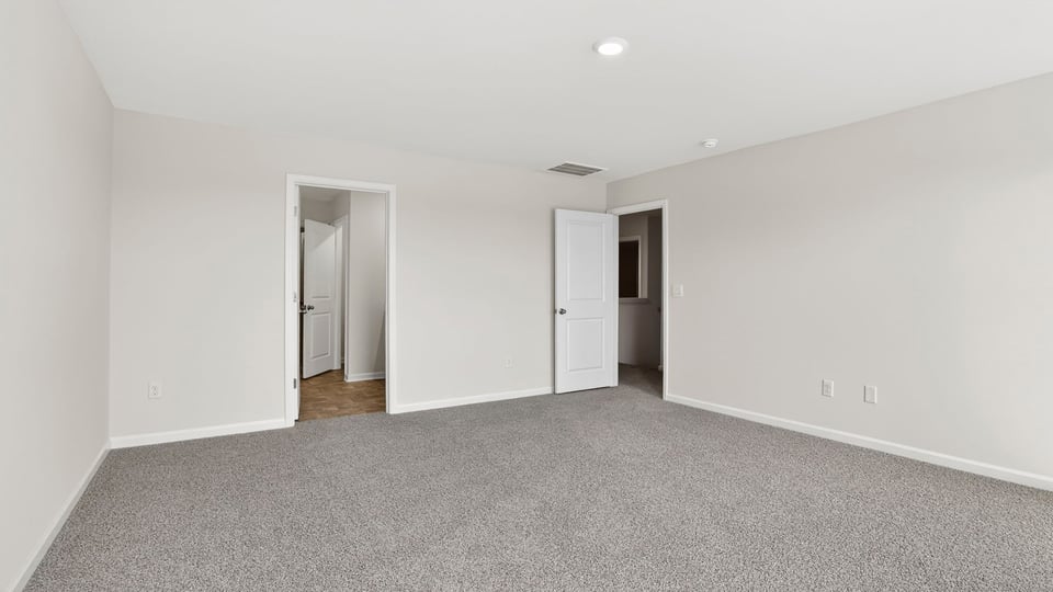 Bedroom with carpet and windows.