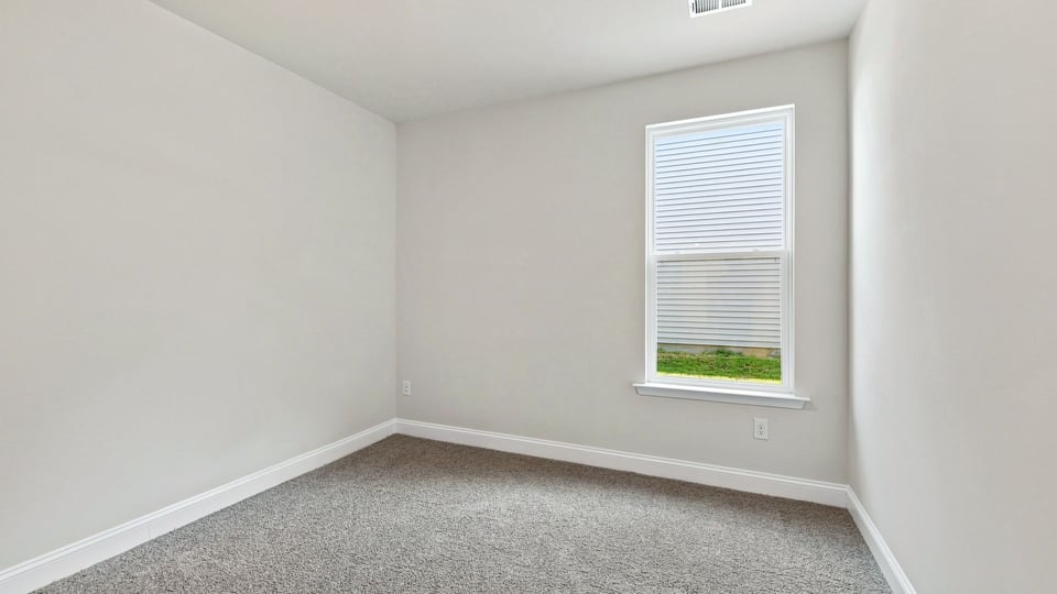 Bedroom with carpet and windows.