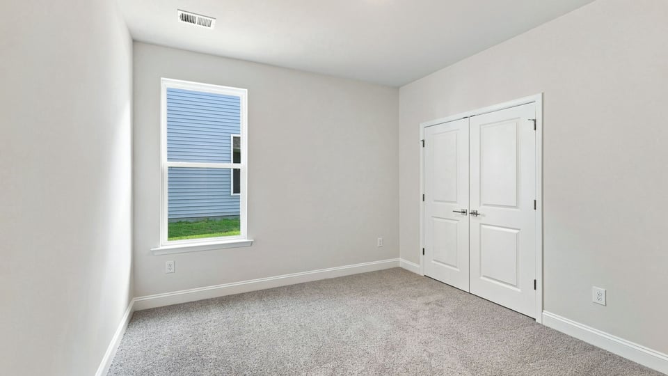 Bedroom with carpet and windows.
