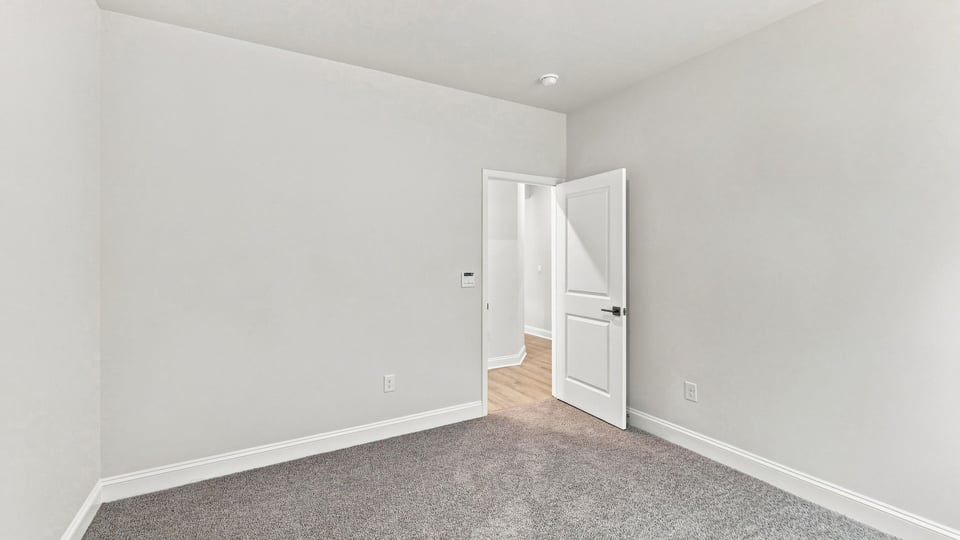 Bedroom with carpet and windows.